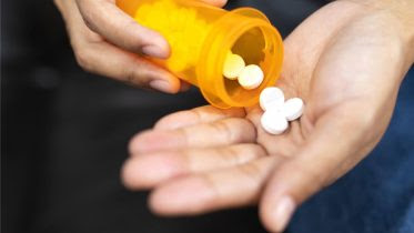 Image name: Man-Pouring-Drugs-into-Hand-Medicine-Aspirin.jpg